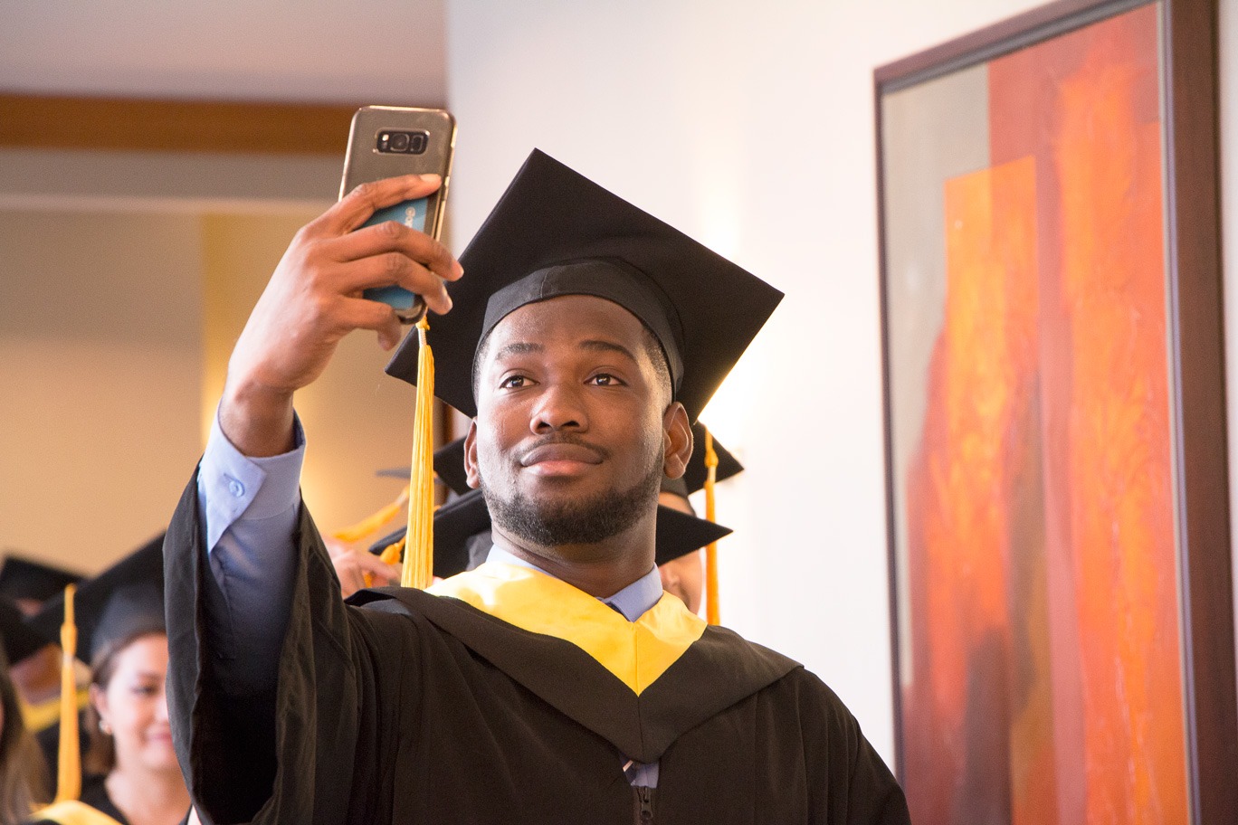 Brighton College graduate of 2018 taking a selfie before entering the ceremony processional.