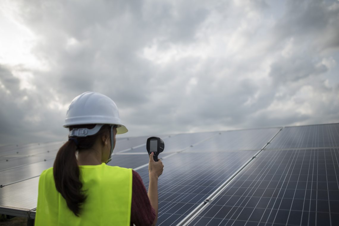 Environmental - Green Jobs. Woman checking solar panels.