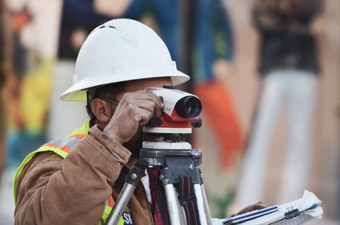 Architectural Technician on a construction site surveying the build site.